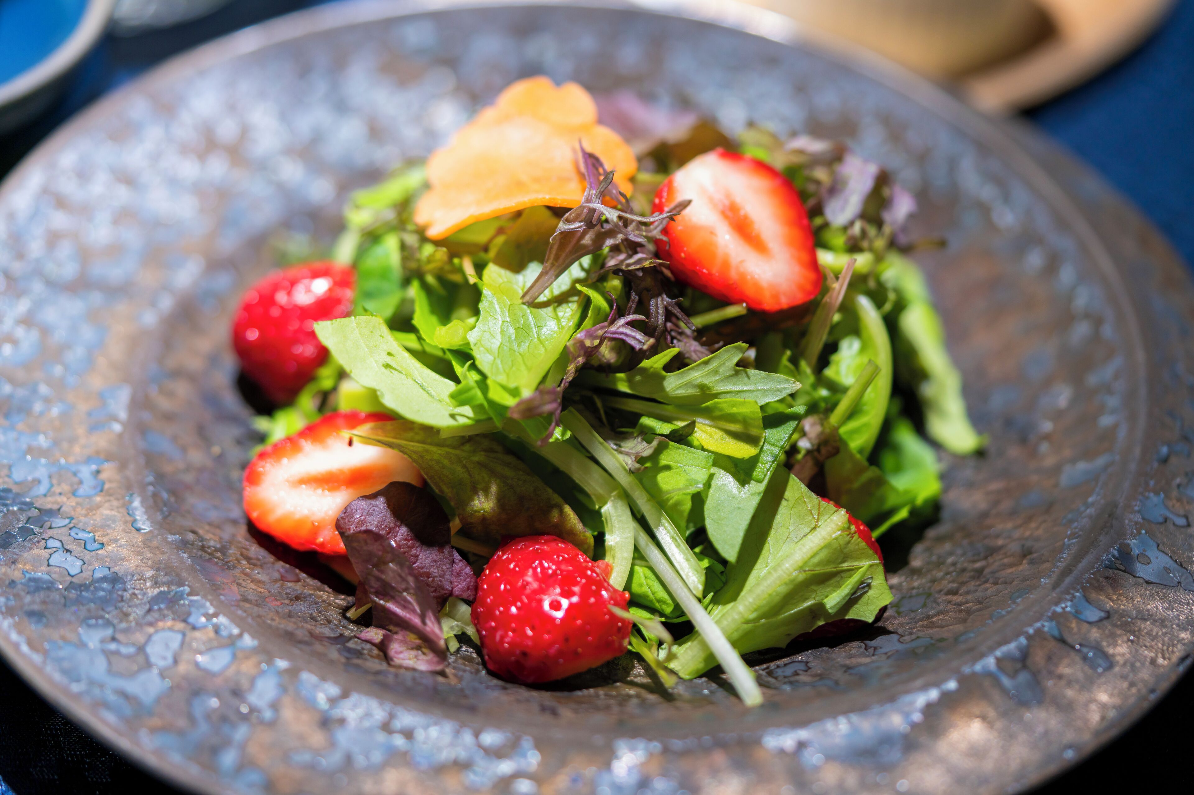 Ensalada con fresas y un plato decorativo.