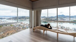 A room with large windows offering a view of a city and a river. - onomichi club (Onomichi)