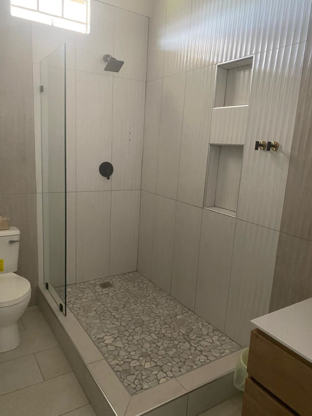 Une salle de bain avec une douche à parois de verre, des toilettes et un lavabo avec un meuble sous-vasque.