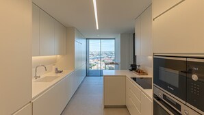 Eine moderne Küche mit einem Bosch-Ofen, einer Spüle und Blick auf die Stadt durch eine Glastür.