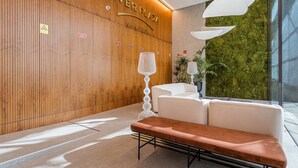 Eine moderne Lobby mit einer Holzwand, einer Bank und einem Sofa.