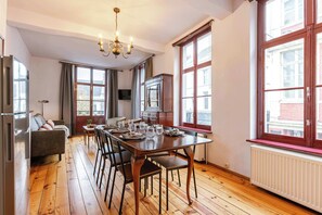 Enjoy meals in the dining area with a table set for four, surrounded by a sofa and large windows offering a city view.