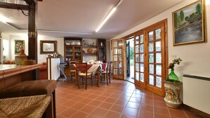 Een eethoek met een tafel voor vier personen, omringd door stoelen, en een keuken met kasten en een koelkast.
