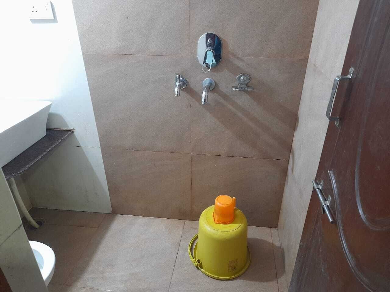 A small bathroom with a toilet, a sink, and a shower area.