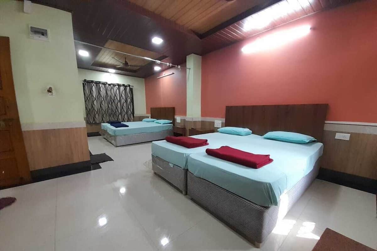 A hotel room with two beds, a large window, and a ceiling fan.