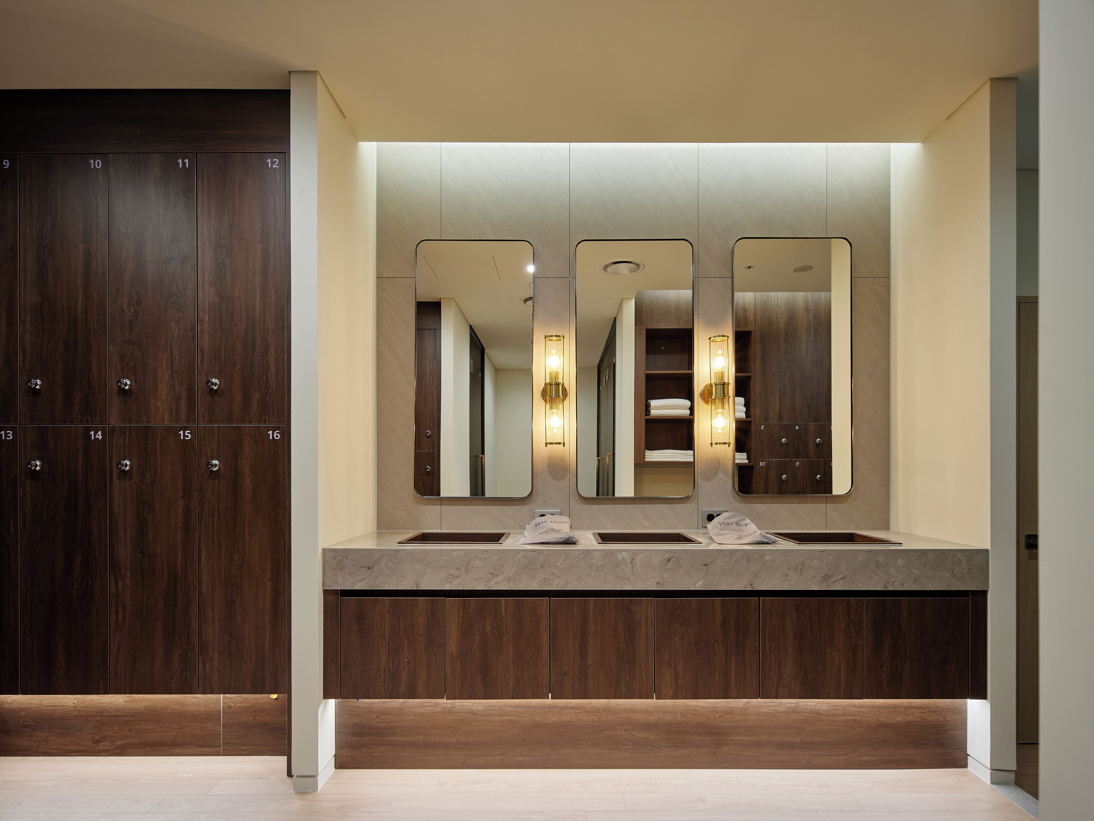 Un baño moderno con un espejo grande, dos lavamanos y un mueble de tocador de madera.