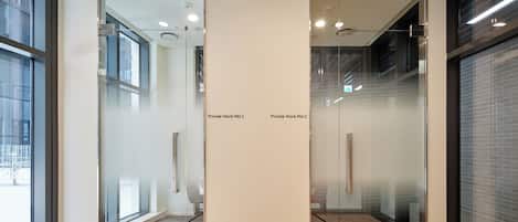 Un espacio de oficina moderno con divisiones de vidrio, una sala de conferencias y vistas a la ciudad.