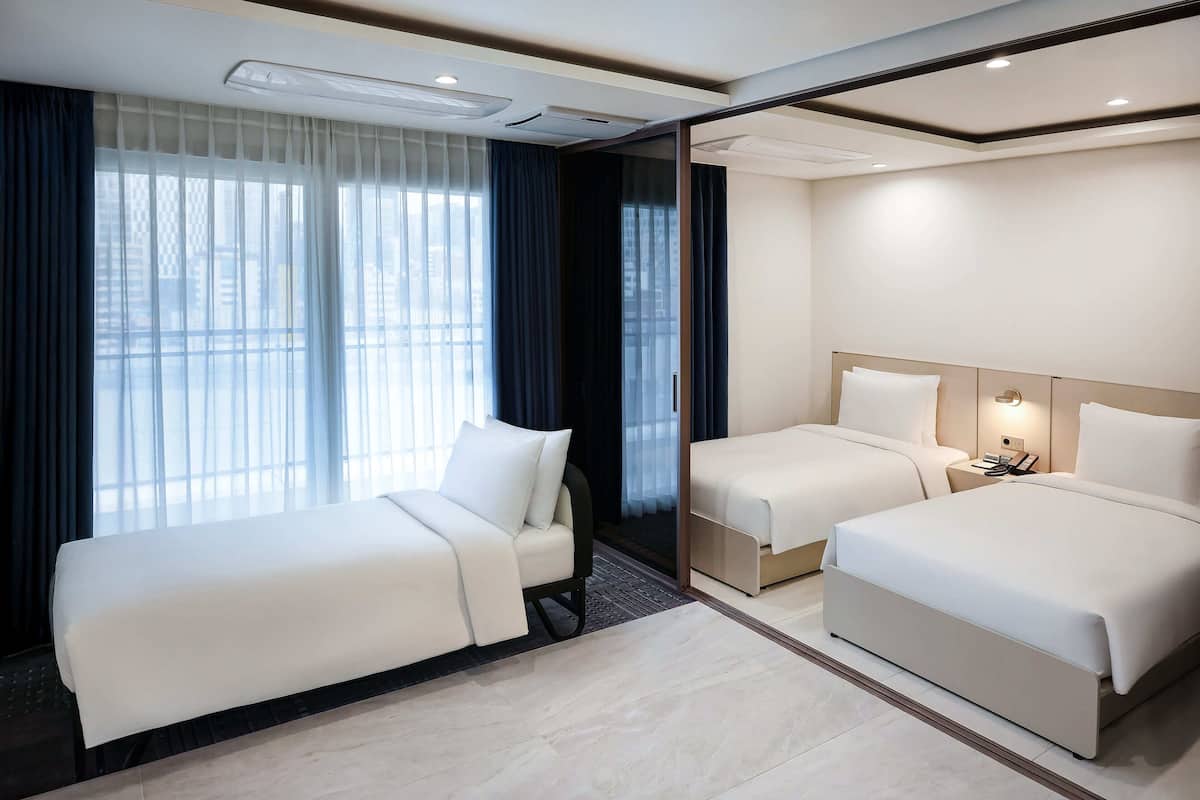 Premier Suite Triple | Duntäcken, värdeförvaringsskåp på rummet och skrivbord