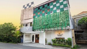 A building with a green ivy-covered facade, a sign for 'Sansari' salon and spa, and a 'GreenGenie' service. - Eco Boo Boo - Green Genesis (Jimbaran)
