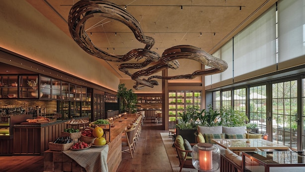 Ein geräumiges Restaurant mit einer langen Theke, Holzboden und einem modernen Deckenstil.