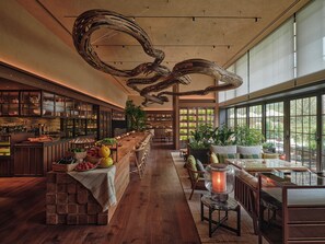 A spacious restaurant with a long counter, wooden flooring, and a modern ceiling design. - Patina Osaka (Osaka)