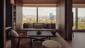 A modern living room with a large window, a sofa, a coffee table, and a bookshelf. - Patina Osaka (Osaka)