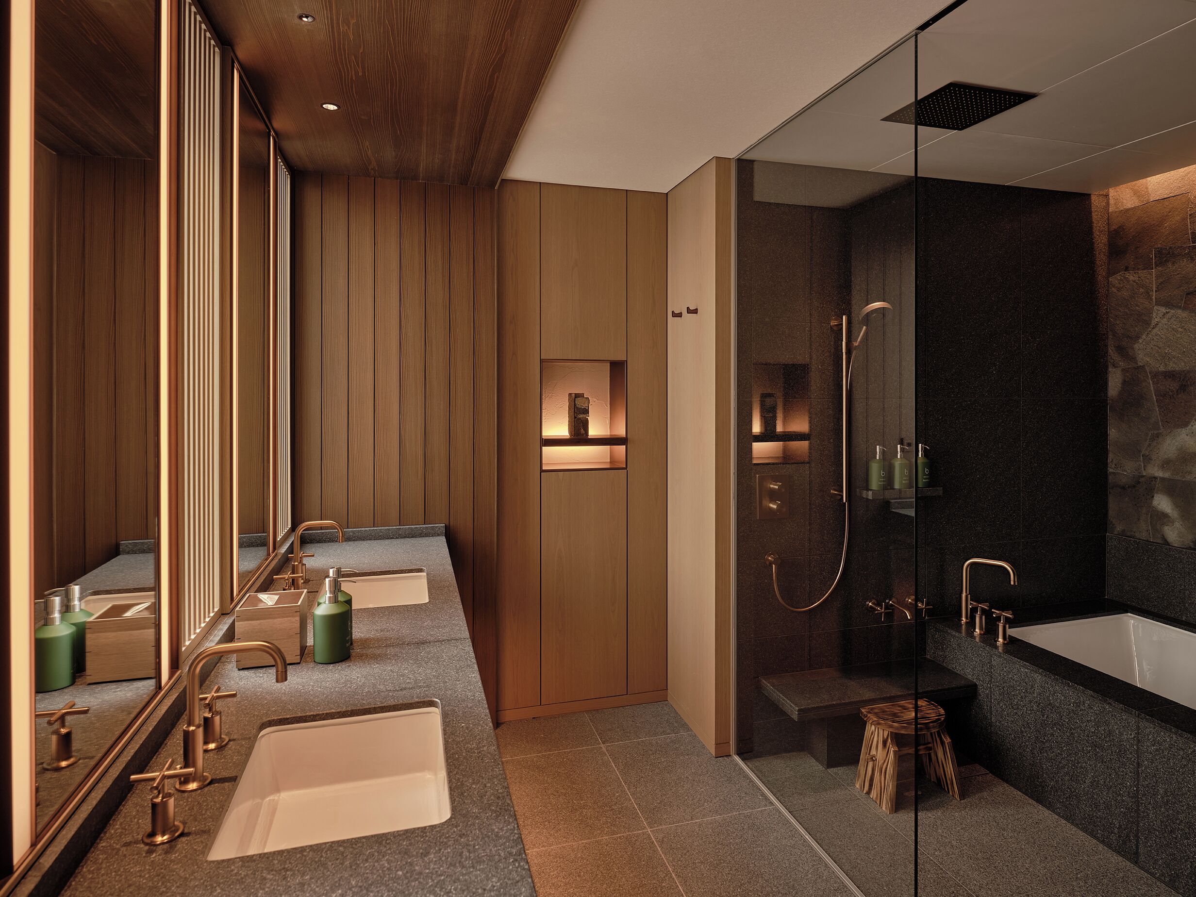 A modern bathroom with a wooden vanity, a glass shower enclosure, and a large mirror.