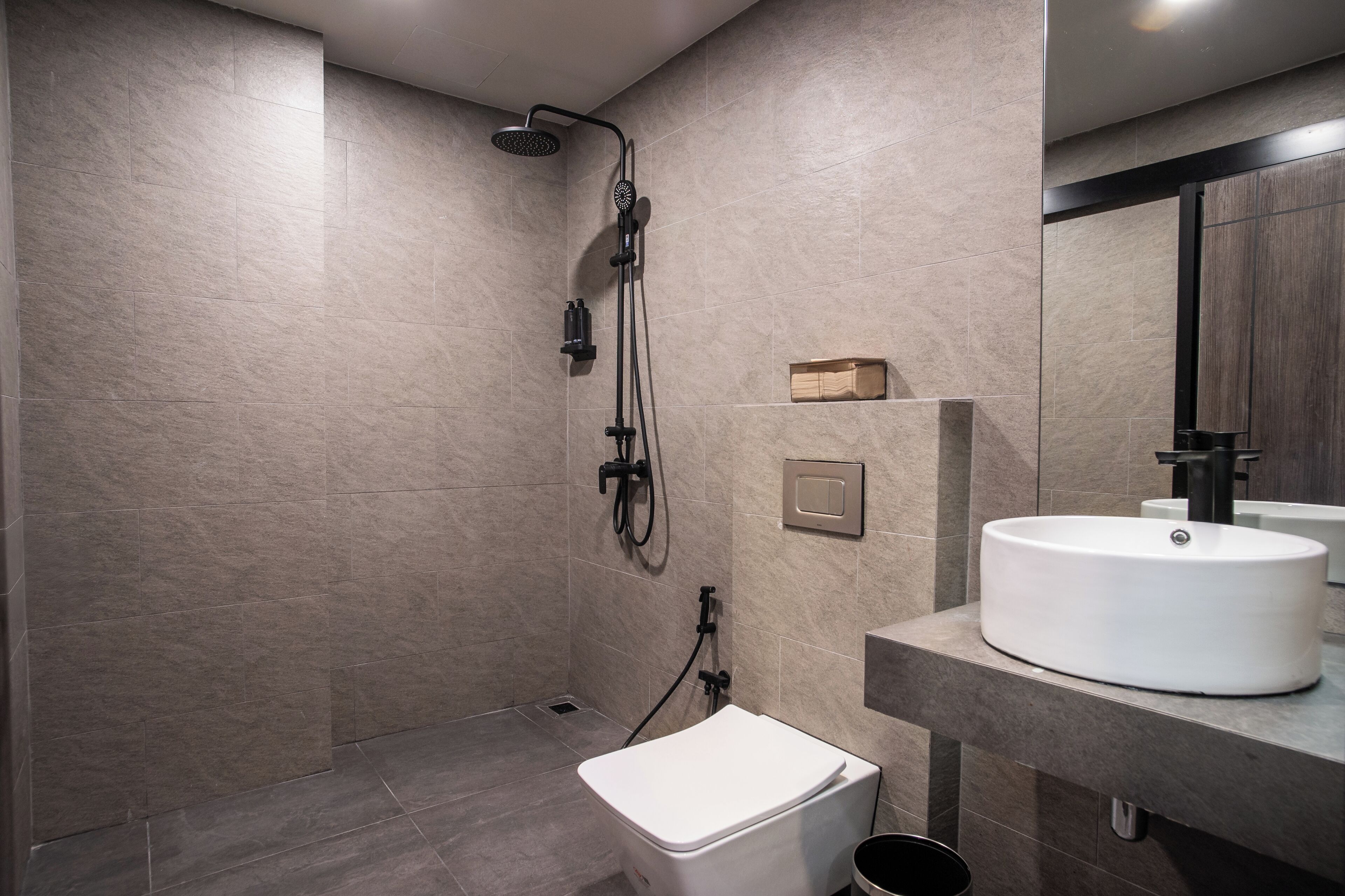 Une salle de bain moderne équipée d’une douche, de toilettes et d’un lavabo.