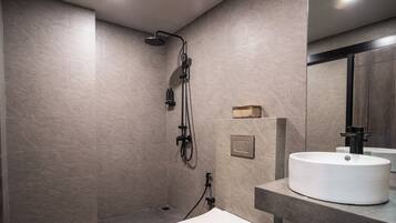 Un baño moderno con ducha, inodoro y lavamanos.