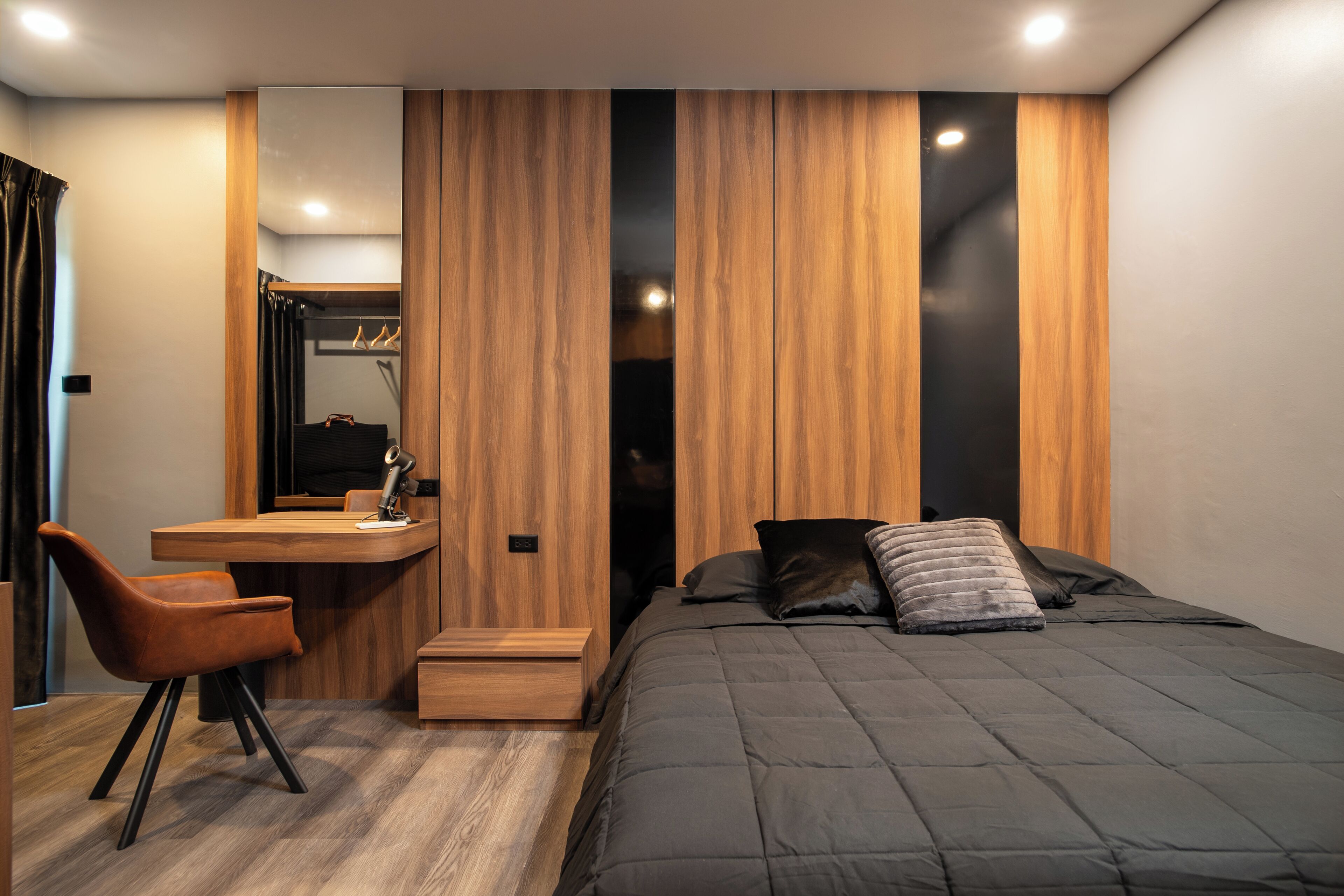 Ein modernes Schlafzimmer mit Bett, Schreibtisch und Stuhl.