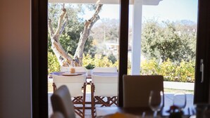 Un coin repas avec une table dressée pour deux personnes, comprenant une carafe en verre, une assiette avec de la nourriture et un verre d’eau.