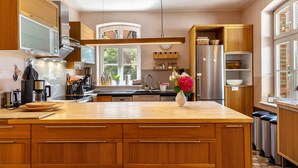 Una cocina moderna con armarios de madera, electrodomésticos de acero inoxidable y una isla central.