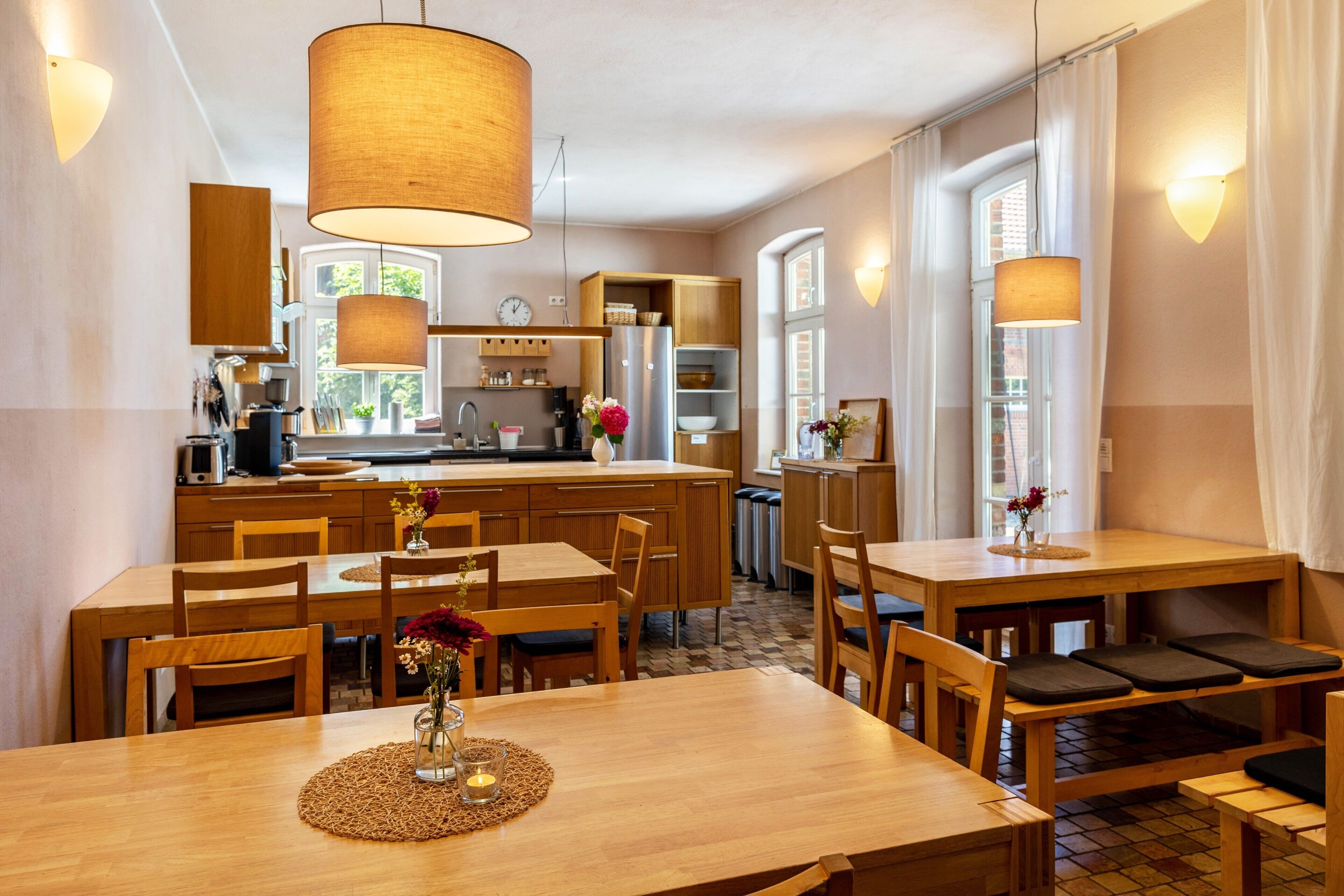 Uma cozinha moderna com armários de madeira, uma ilha central e luminárias pendentes.