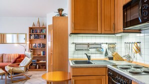 Una cocina con armarios de madera, un microondas, un lavabo y una estufa.