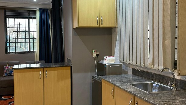 Een keuken met houten kastjes, een granieten aanrechtblad en een inbouwspoelbak.