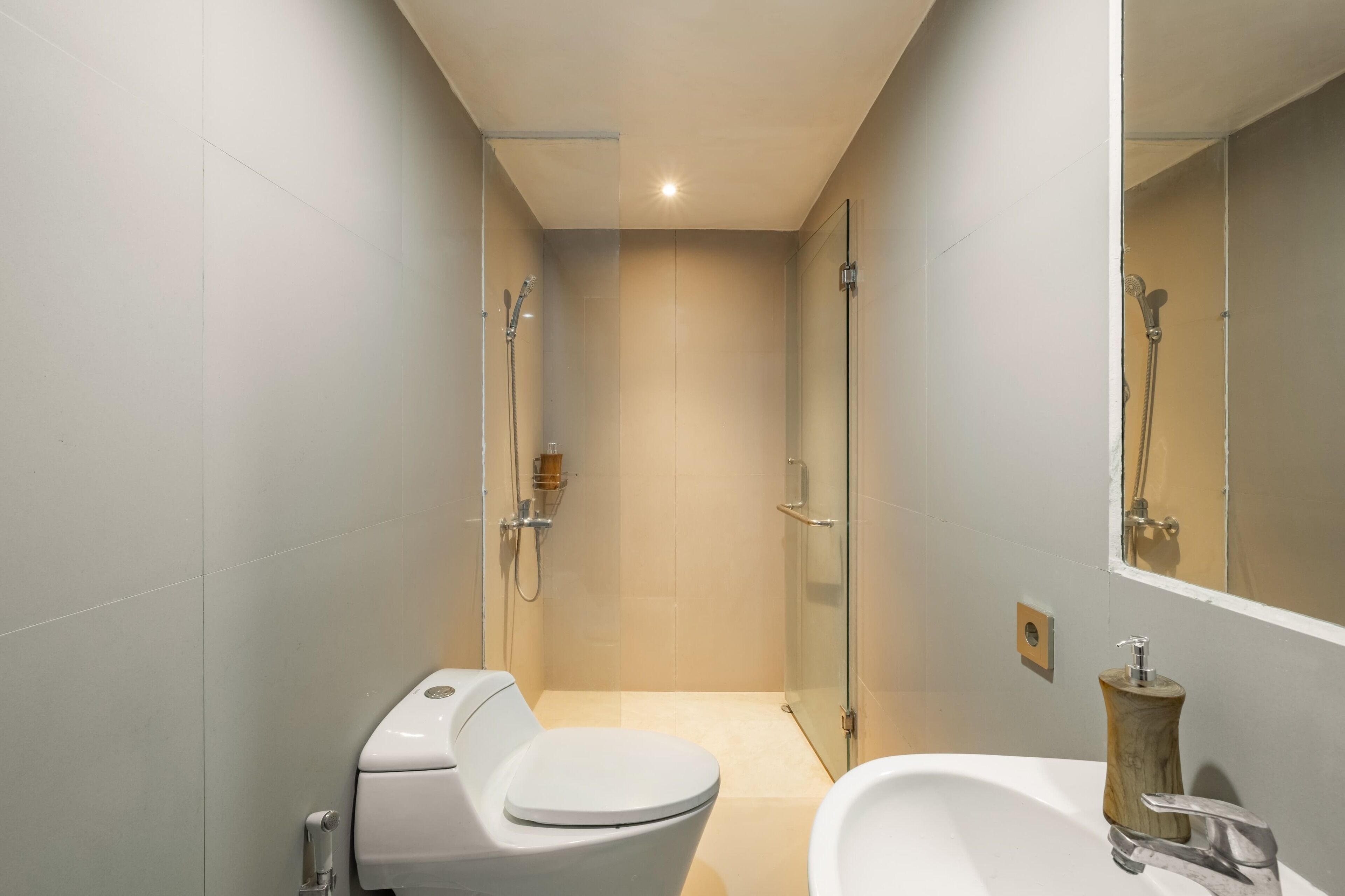 A modern bathroom with a toilet, sink, and glass-enclosed shower.