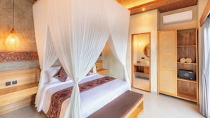 A bedroom with a canopy bed, wooden headboard, bedside table, and a built-in wardrobe with shelves. - Weda Villas (Ubud)