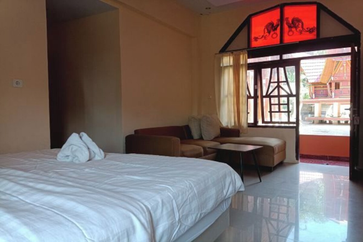 Une chambre d’hôtel avec un lit, un canapé, une petite table et une vue sur l’extérieur.