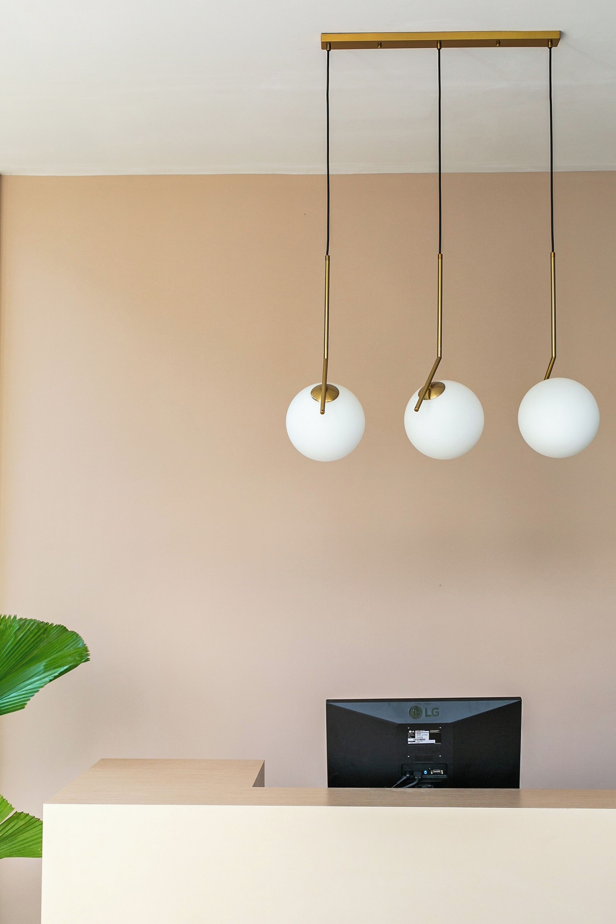 Una habitación moderna con pared color beige, un escritorio de madera y un televisor de pantalla plana.