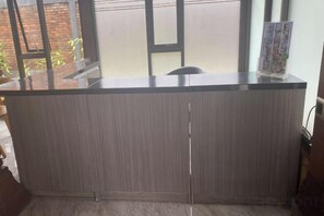 A reception desk with a glass top, a chair, and a poster on the wall.
