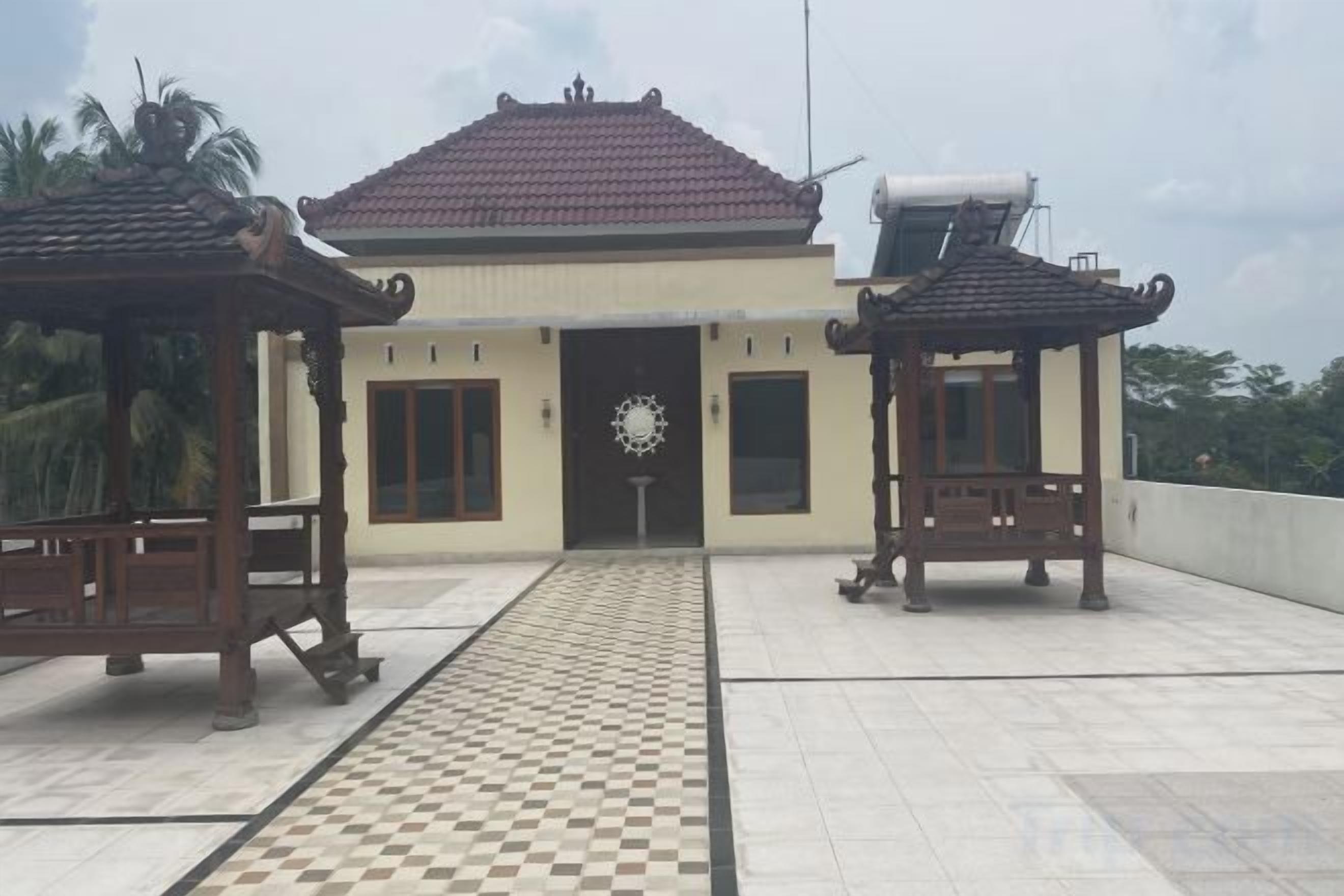 Un edificio con entrada de baldosas, dos gazebos de madera y un suelo a cuadros.