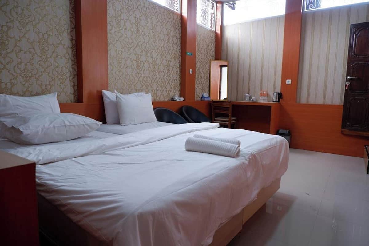 Une chambre d’hôtel avec un grand lit, un bureau et un miroir.
