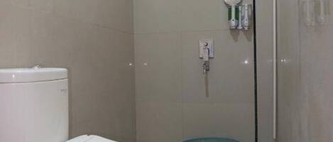 Un baño pequeño con azulejos, que incluye inodoro, ducha y bidé.