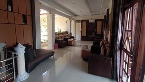Um hall amplo com área de estar, balcão de recepção e vista para o exterior.