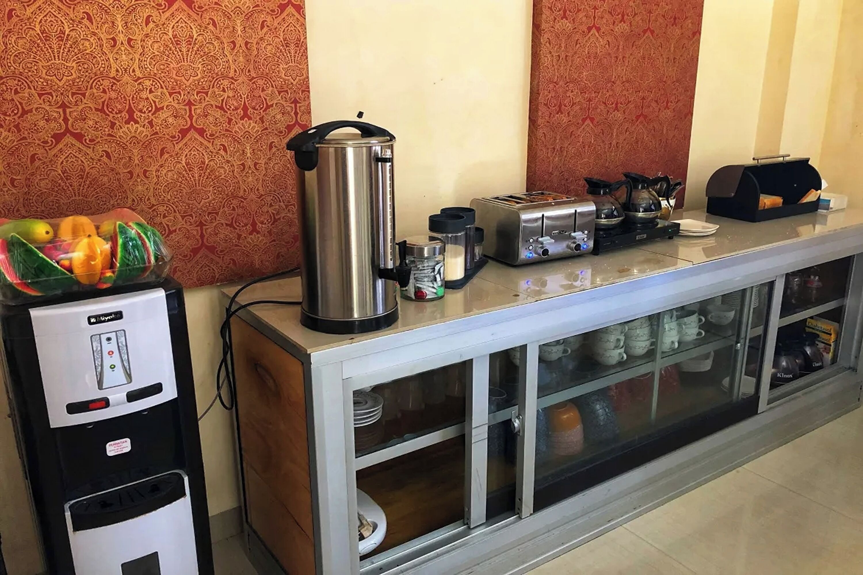 Eine Küchenzeile mit Kaffeemaschine, Toaster, Wasserkocher und einer Obstschale.