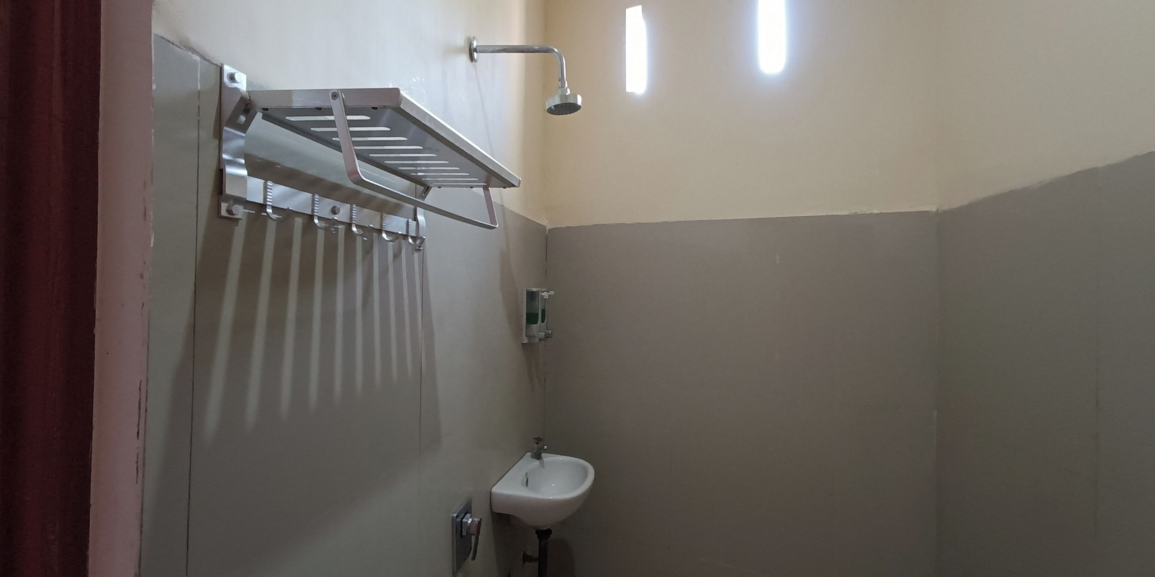 A bathroom with a shower, a sink, and a towel rack.