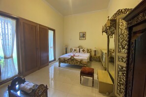 Classic hotel room with a large bed, wooden wardrobe, and a large mirror.