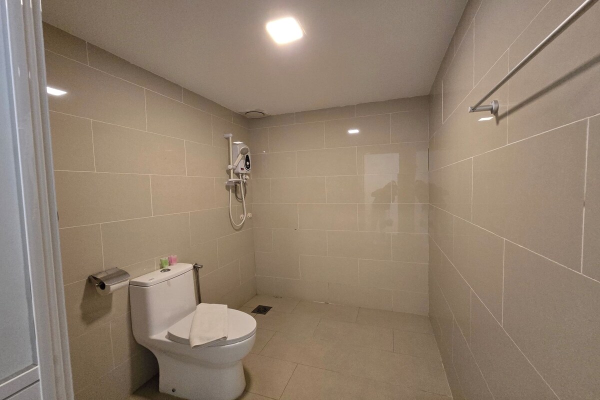 Un baño pequeño y limpio con inodoro, ducha y secador de manos.