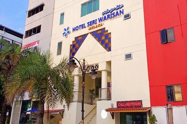 Ein Hotel namens Hotel Seri Warisan mit einer gut sichtbaren Beschilderung und angegebener Kontaktnummer.