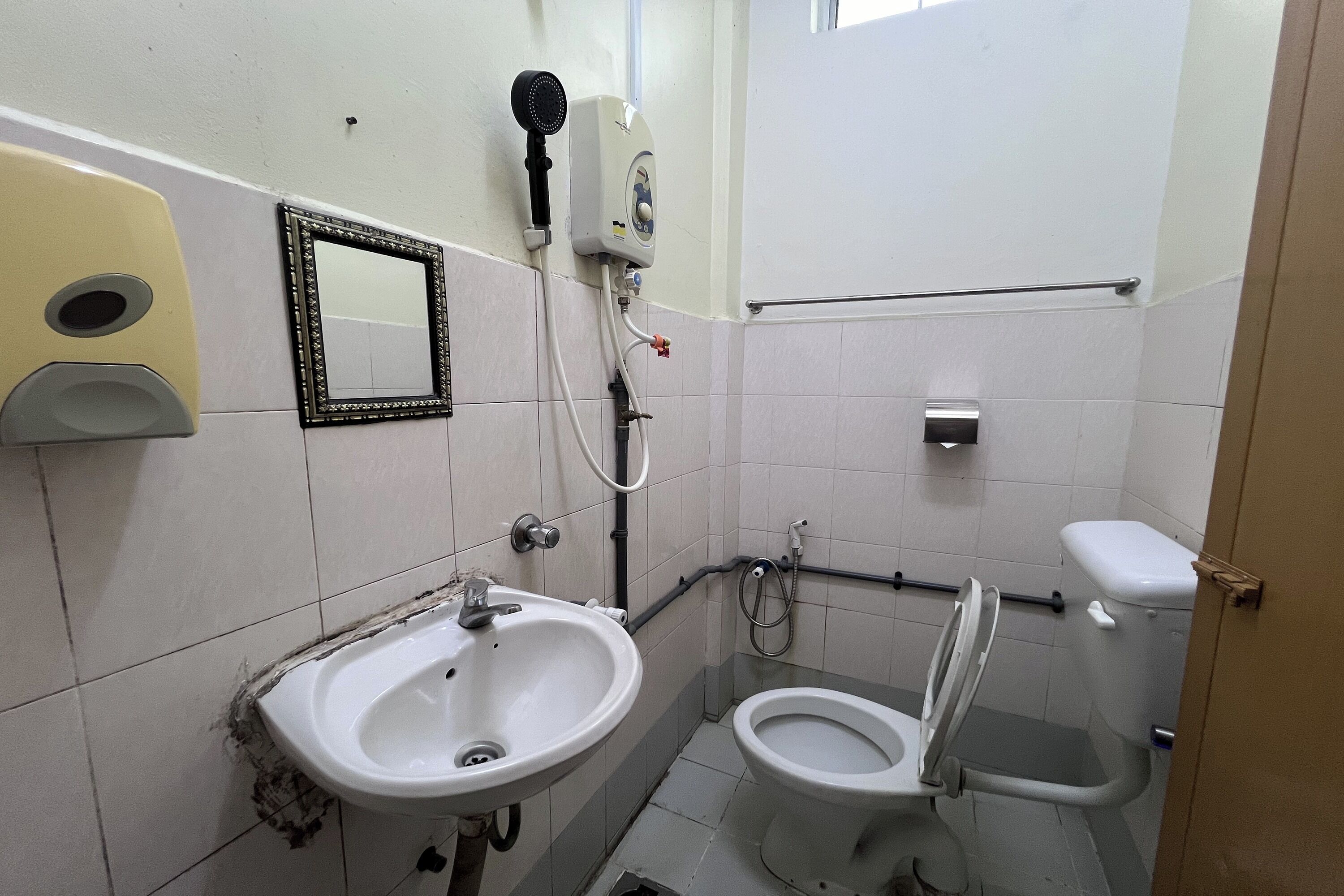 Une salle de bain équipée d’un lavabo, de toilettes et d’un sèche-mains.