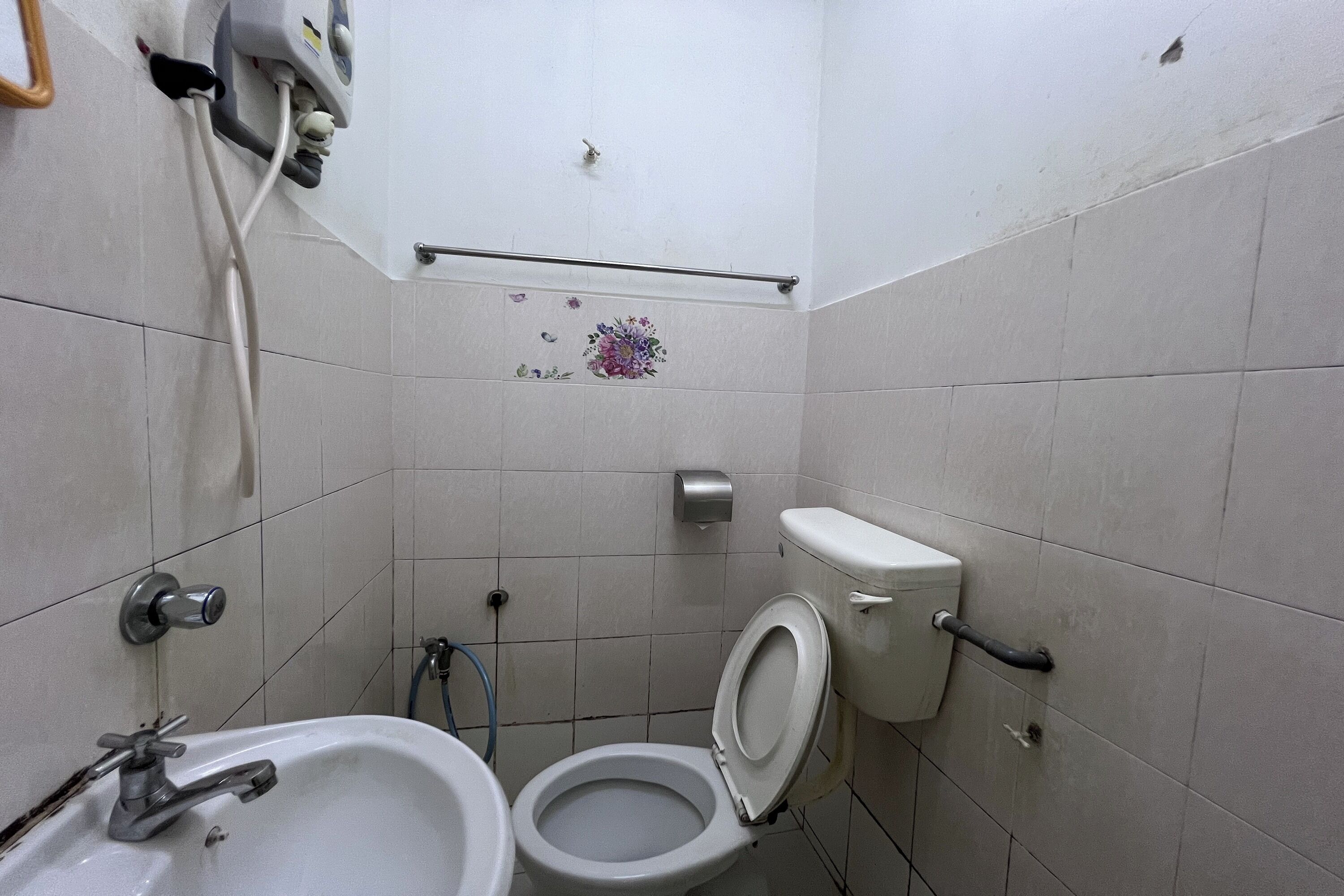 A small bathroom with a toilet, sink, and a hand dryer.