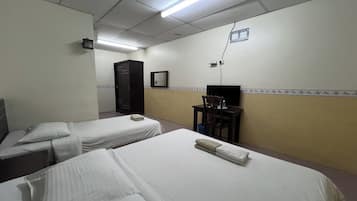 Una habitación de hotel con dos camas individuales, un escritorio con silla, un armario y un televisor.