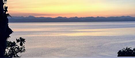 A serene body of water with a clear horizon and distant mountains.