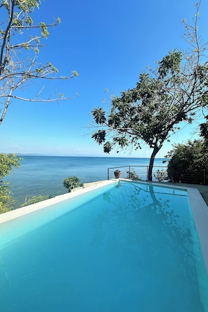 Un cielo azul despejado, una piscina y vistas al mar.