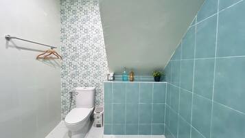A bathroom with a toilet, a sink, and a shower area.