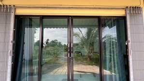 A building with large glass doors and a yellow awning. - Kuan Mapraw Villa 3 (Phatthalung)
