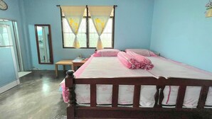 A bedroom with a wooden bed, a nightstand, a mirror, and a window with curtains. - Baan Bonsuan Hill Guesthouse (Kathu)