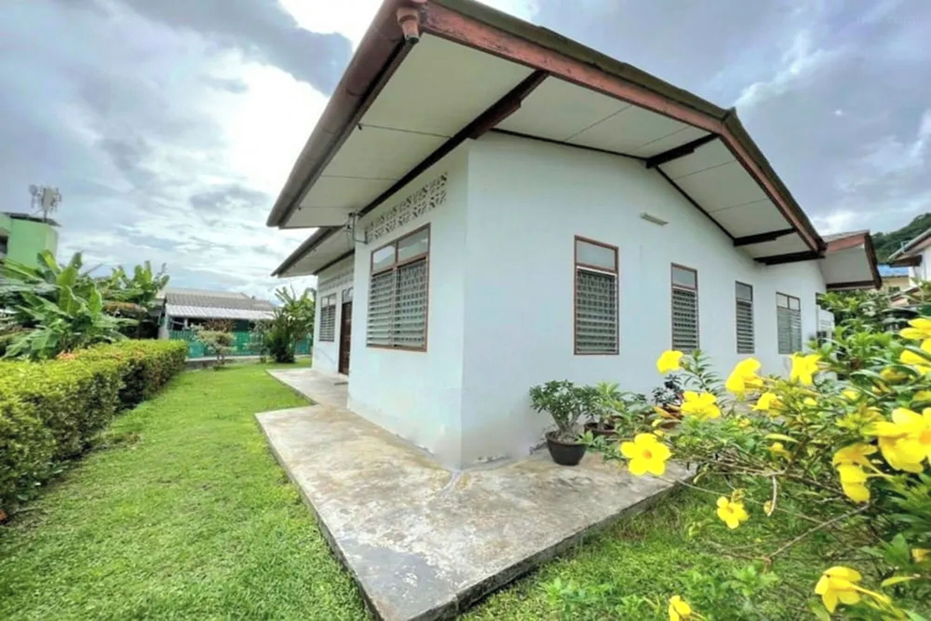 A single-story building with a sloped roof and a small porch area.