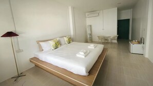 Une chambre d’hôtel moderne, dotée d’un grand lit, de tables de chevet, d’un bureau et d’une chaise.
