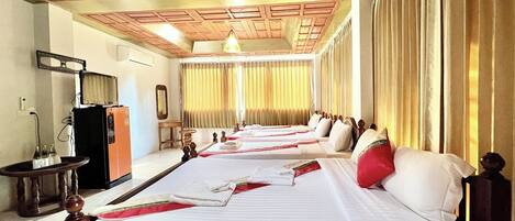 Una habitación de hotel con una cama grande, un escritorio, un espejo y un armario.